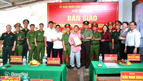 Các thành viên Khối thi đua 13 UBND thành phố Đồng Nai trao quyết định bàn giao nhà tình thương cho gia đình ông Phạm Văn Hoàng. Ảnh: Nguyệt Hà