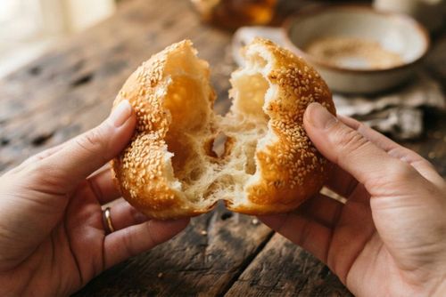 Bánh tiêu Việt Nam là món ăn vặt dân dã với hương vị đặc trưng: lớp vỏ vàng rụm, giòn dai quyện cùng vị ngọt thanh của đường và vị bùi bùi, thơm nồng của mè trắng. Phần ruột bánh rỗng, mềm xốp, đôi khi thoảng hương thơm nhẹ từ bột nở. (Ảnh: BNC)
