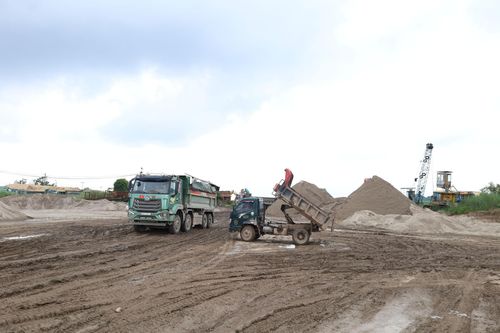 Bãi chứa cát sỏi ở xã Phú Xuyên vẫn chất tải, hoạt động trong chiều 1-7. Ảnh: Kim Nhuệ