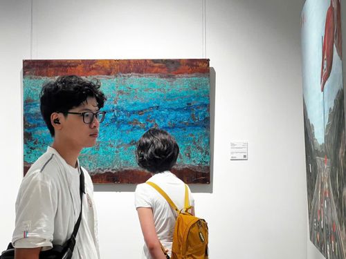 Công chúng thưởng thức những tác phẩm hội họa tại triển lãm.