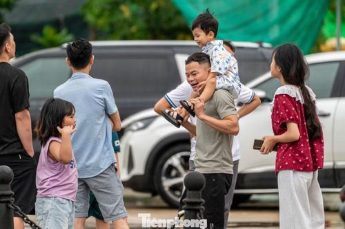 Nhiều khách du lịch ở nơi khác đến tranh thủ trời ngớt mưa ra biển chụp ảnh check-in trước giờ bão về.