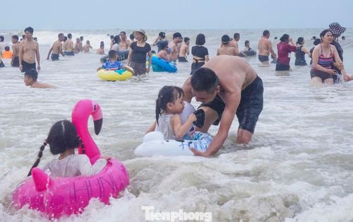 "Biển hôm nay rất đông, nước hơi đục, sóng lớn do ảnh hưởng của bão nhưng cả gia đình vẫn xuống tắm, chúng tôi vui chơi ở khu vực gần bờ để đảm bảo an toàn", anh Thuần (trú Hà Nội) chia sẻ.