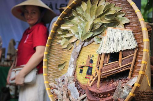 Tác phẩm nhà sàn và hoạt cảnh đời sống của đồng bào Mơ Nông được khắc họa bởi chất liệu gỗ quế và thổ cẩm. Ảnh: ALĂNG NGƯỚC