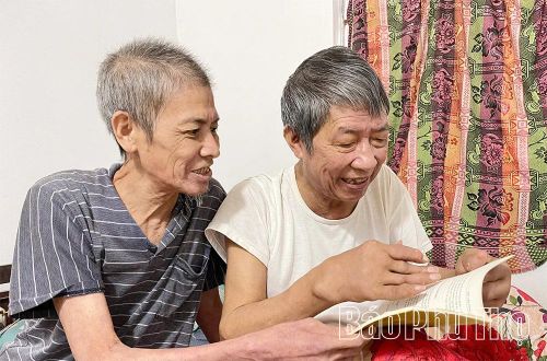 Ông Hán Xuân Chính (bên trái) và Hán Văn Hiểu tâm đắc với cuốn sách “Văn Lang - Làng cười” sưu tầm những tích xưa, truyện cười của quê hương.