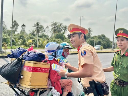 Cán bộ CSGT phát nước suối miễn phí, lồng ghép tuyên truyền về trật tự an toàn giao thông.