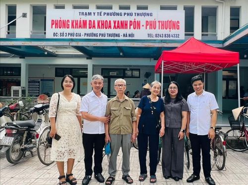 Vợ chồng cụ Phùng Chí Thức và cụ Nguyễn Thị Vui, tổ dân phố Phú Gia 3, chụp ảnh lưu niệm cùng lãnh đạo phường và các y, bác sĩ sau buổi khám sức khỏe. Ảnh: Lê Hà