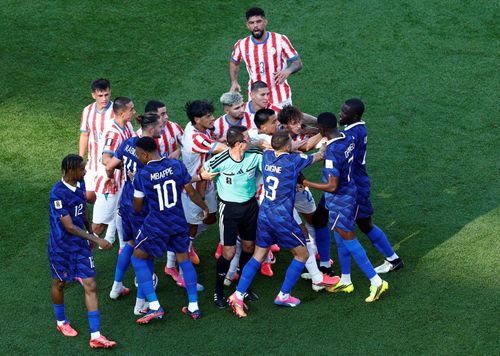 Ousmane Dembele của Pháp đụng độ với các cầu thủ Paraguay sau khi Andres Cubas phạm lỗi với Kylian Mbappe. Ảnh: Jeenah Moon/Reuters.