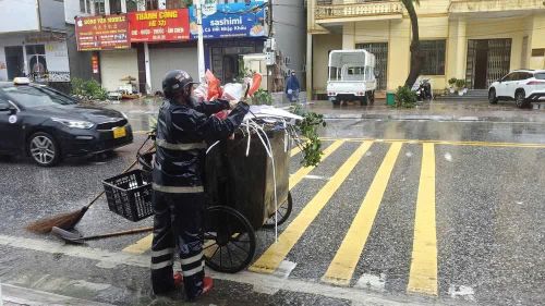 Lực lượng vệ sinh môi trường phường Móng Cái 1 dọn dẹp rác sau bão số 1. Ảnh: TTXVN phát