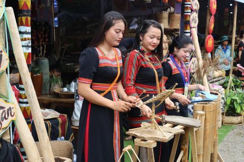 Thiếu nữ Trà Leng trong trang phục truyền thống biểu diễn nhạc cụ tại lễ hội.