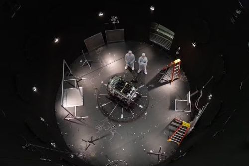 Hai kỹ sư làm việc cho Katalyst Space đứng cạnh tàu vũ trụ của họ bên trong SES (Máy mô phỏng môi trường không gian) tại Trung tâm không gian Goddard của NASA ở Greenbelt, Maryland, ngày 17/4. (Ảnh: NASA/AP)