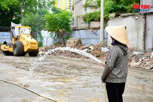 Công nhân tưới nước giảm bụi tại khu vực thi công.