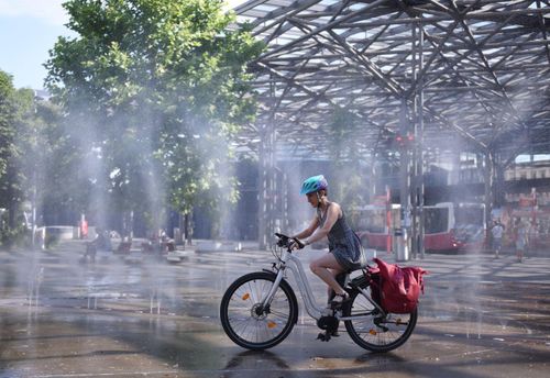 Người dân tránh nóng bên đài phun nước tại Vienna, Áo. Ảnh: THX/TTXVN