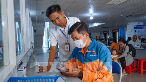 Thành viên Tổ Công nghệ số cộng đồng hướng dẫn người dân cài đặt và sử dụng các ứng dụng số, góp phần lan tỏa Phong trào “Bình dân học vụ số” đến từng hộ gia đình. Ảnh: Minh Phú – TTXVN