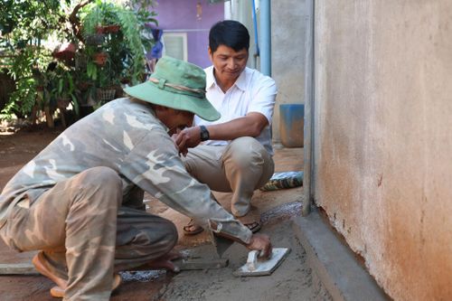 Ông Lý The (áo trắng) dành nhiều thời gian để vận động người dân thay đổi thói quen sinh hoạt, nâng cao ý thức giữ gìn vệ sinh môi trường