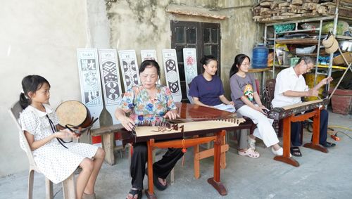 Vợ chồng NNƯT Nguyễn Thị Lý-Ngô Lực say mê luyện tập hò khoan cùng các cháu tại gia đình - Ảnh: M.Nhân