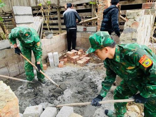 Cán bộ, chiến sỹ Đồn Biên phòng Thị Hoa giúp nhân dân xây dựng chuồng trại, di dời gia súc ra khỏi gầm sàn nhà ở.