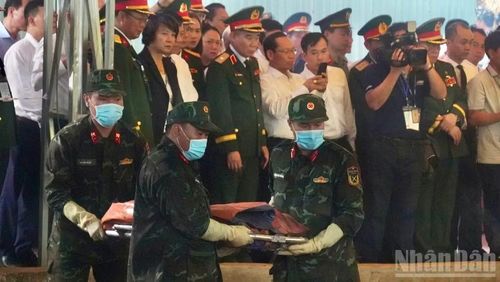 Lực lượng quy tập đưa hài cốt liệt sĩ và di vật từ rãnh chôn lên trên.