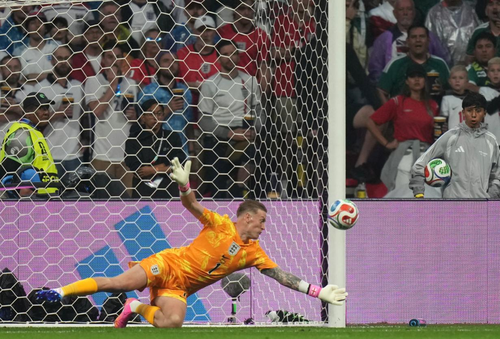Thủ môn Jordan Pickford bay người cản phá cú đánh đầu hiểm hóc của Raul Jimenez. Ảnh: AP.