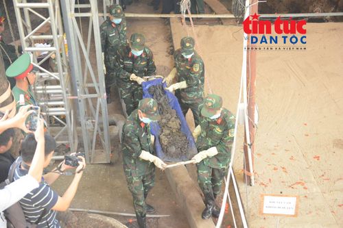 Lực lượng chức năng đưa hài cốt ra khỏi hố chôn tập thể tại Công viên Lê Thị Riêng.