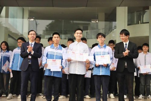 Phạm Hoàng Minh (áo trắng, đứng giữa) nhận giấy khen và phần thường do lãnh đạo trường trao tặng. Ảnh: NVCC