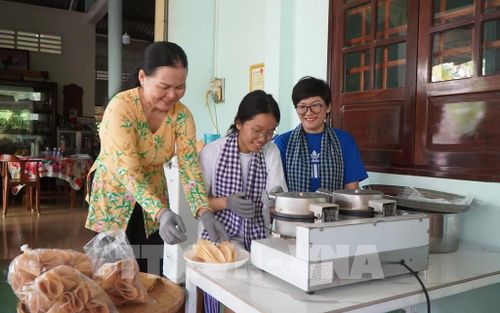 Du khách trải nghiệm làm bánh kẹp xoài. Ảnh: Nhựt An - TTXVN