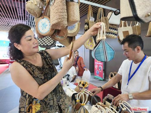 Người tiêu dùng thích thú khi mua được chiếc túi làm từ mây tre đan do hộ kinh doanh Phạm Hồng Vũ sản xuất