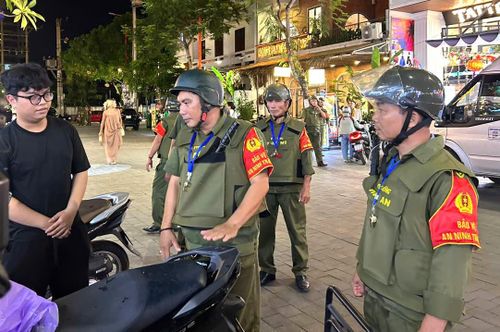 Lực lượng bảo vệ an ninh trật tự cơ sở phường Ngũ Hành Sơn nhắc nhở người dân chấp hành các quy định về trật tự. Ảnh: NGỌC HÀ