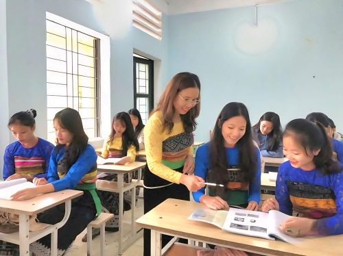 Giáo viên hướng dẫn học sinh tìm hiểu tiếng nói, chữ viết dân tộc trong một lớp học, góp phần gìn giữ và lan tỏa bản sắc văn hóa truyền thống