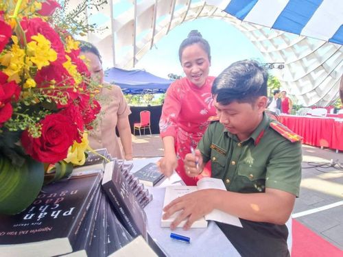 Tác giả Nguyễn Đỗ Văn Quốc ký tặng sách cho bạn đọc trong ngày ra mắt tiểu thuyết "Phản chiếu đảo ngược".