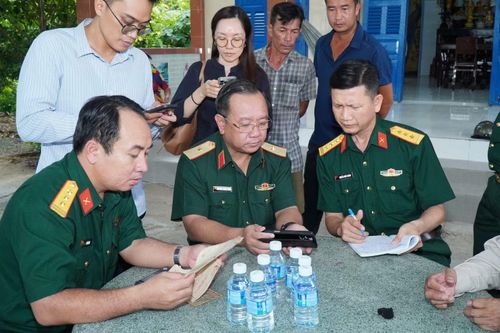 Thiếu tướng Nguyễn Thành Trung - Chính ủy Bộ Tư lệnh TPHCM (hàng ngồi, thứ hai từ trái qua) đang xác minh thông tin nhân thân liệt sĩ Huỳnh Văn Quên. Ảnh: Bộ Tư lệnh TPHCM.