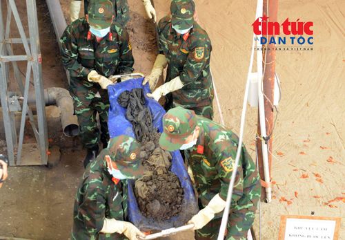 Lực lượng chức năng đưa hài cốt ra khỏi hố chôn tập thể tại Công viên Lê Thị Riêng.