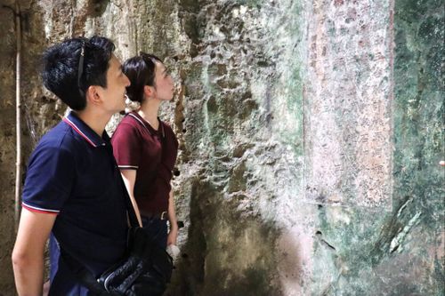 Khách Nhật Bản tìm hiểu về di sản tư liệu ma nhai ở danh thắng Ngũ Hành Sơn. Ảnh: QUỐC TUẤN
