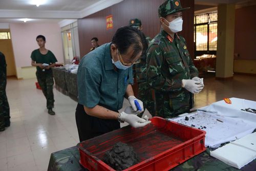 Bác sĩ Trần Văn Bản cùng cán bộ chiến sĩ Đội K74 tỉ mỉ tìm di cốt liệt sĩ trong lớp bùn đất