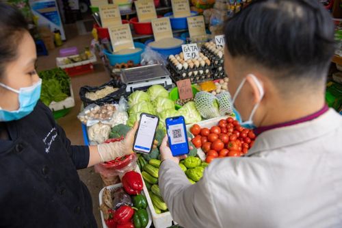 Người mua hàng và người bán hàng đều thuận tiện với hình thức thanh toán không tiền mặt. Ảnh: M.H
