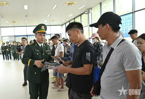  Thành viên "Tổ dân vận đối ngoại" phát tờ rơi tuyên truyền tới người dân tại khu vực Cửa khẩu quốc tế Móng Cái. 