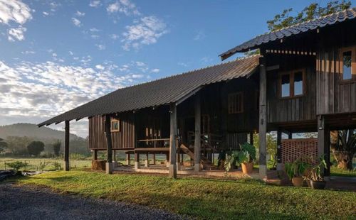 Về mặt kiến trúc, Raintree Lane Farm House sử dụng hình thái mái dốc truyền thống, kết hợp kết cấu gỗ mộc mạc và vật liệu địa phương. Các chi tiết được tiết giảm tối đa. Không có những đường nét cầu kỳ hay mặt đứng phức tạp, toàn bộ công trình hướng đến cảm giác nhẹ nhàng, gần gũi và phù hợp với khí hậu nhiệt đới của Chiang Mai. Nhìn từ xa, ngôi nhà giống như một phần của những ngôi nhà nông thôn truyền thống hơn là một công trình hiện đại.