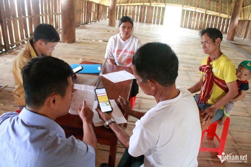 Cán bộ Trung tâm Phục vụ hành chính công xã Đăk Kôi hướng dẫn người dân cách cài đặt ứng dụng VNeID. Ảnh: Ngọc Chí
