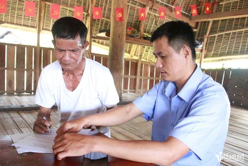 Già A Bria (bên trái), thôn Kon Mong Tu, xã Đăk Kôi vui mừng khi cán bộ xã về tận thôn giúp ông làm các thủ tục về chế độ chính sách dành cho người cao tuổi. Ảnh: Ngọc Chí