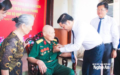 Đồng chí Hoàng Nghĩa Hiếu – Phó Bí thư Thường trực Tỉnh ủy, Chủ tịch HĐND tỉnh trao Huy hiệu 70 tuổi Đảng cho đồng chí Trần Thanh Phong, sinh hoạt tại Chi bộ khối Nghi Hòa 1, phường Cửa Lò. Ảnh: Mai Hoa