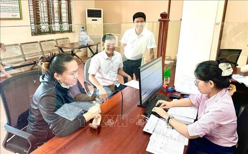 Cán bộ Ngân hàng Chính sách xã hội hoàn tất hồ sơ vay vốn cho khách hàng tại phường Đồng Văn (Ninh Bình).