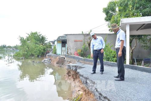 Lãnh đạo Sở Nông nghiệp và Môi trường tỉnh Đồng Tháp khảo sát hiện trường vụ sạt lở xảy ra vào rạng sáng 18/6 trên tuyến đường bờ Tây sông Cổ Cò, đoạn qua ấp Thái Hòa. Ảnh: Công Trí - TTXVN 
