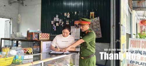 Công an phường Đông Sơn hướng dẫn hộ kinh doanh ký cam kết đảm bảo hành lang an toàn giao thông.