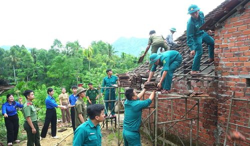 Các lực lượng xã Quế Phước hỗ trợ gia đình chính sách sửa chữa nhà ở. Ảnh: MINH THÔNG