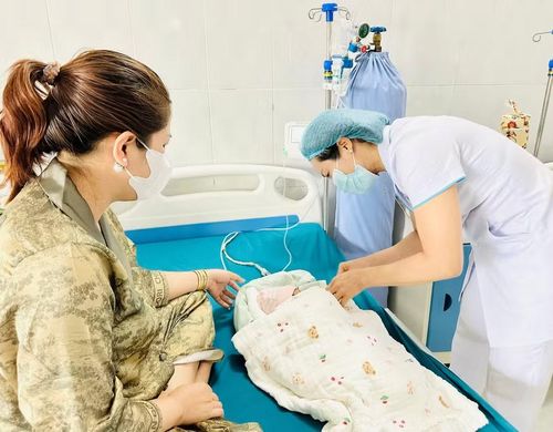 Bà Lâm Thị Thu Minh (bên trái, xã Biển Hồ) chăm sóc cháu ngoại. Ảnh: N.N