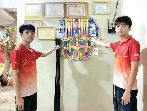 Trần Võ Tuấn Kiệt (bìa trái) và Trần Võ Trí Tín giới thiệu thành tích thi đấu môn Karate của mình. Ảnh: R.H
