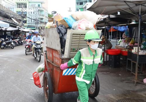 Chị Nguyễn Thị Thúy Vi kéo những xe rác nặng trĩu về điểm tập kết.