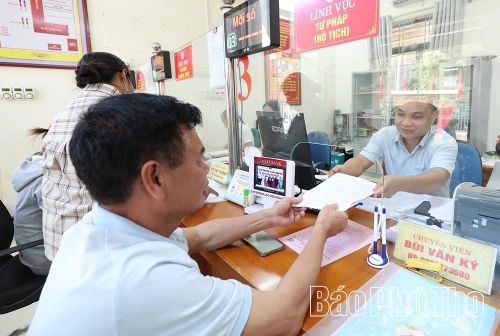 Cán bộ Trung tâm Phục vụ hành chính công xã Lạc Sơn tiếp nhận, giải quyết hồ sơ của người dân.