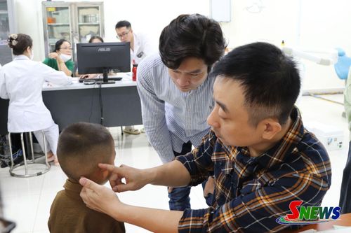 Bác sĩ khám cho trẻ bị dị tật tai.