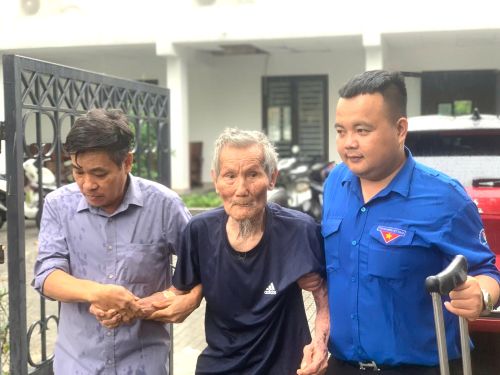 Người nhà và đoàn thanh niên dìu thân nhân liệt sĩ đến lấy mẫu. 