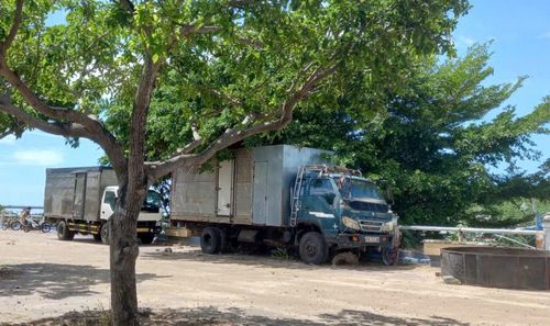 Người dân ngang nhiên biến mặt bờ kè Bạch Đằng thành "sân riêng" để xếp hàng hóa, đậu đỗ xe ô tô. Ảnh: Việt Tường.